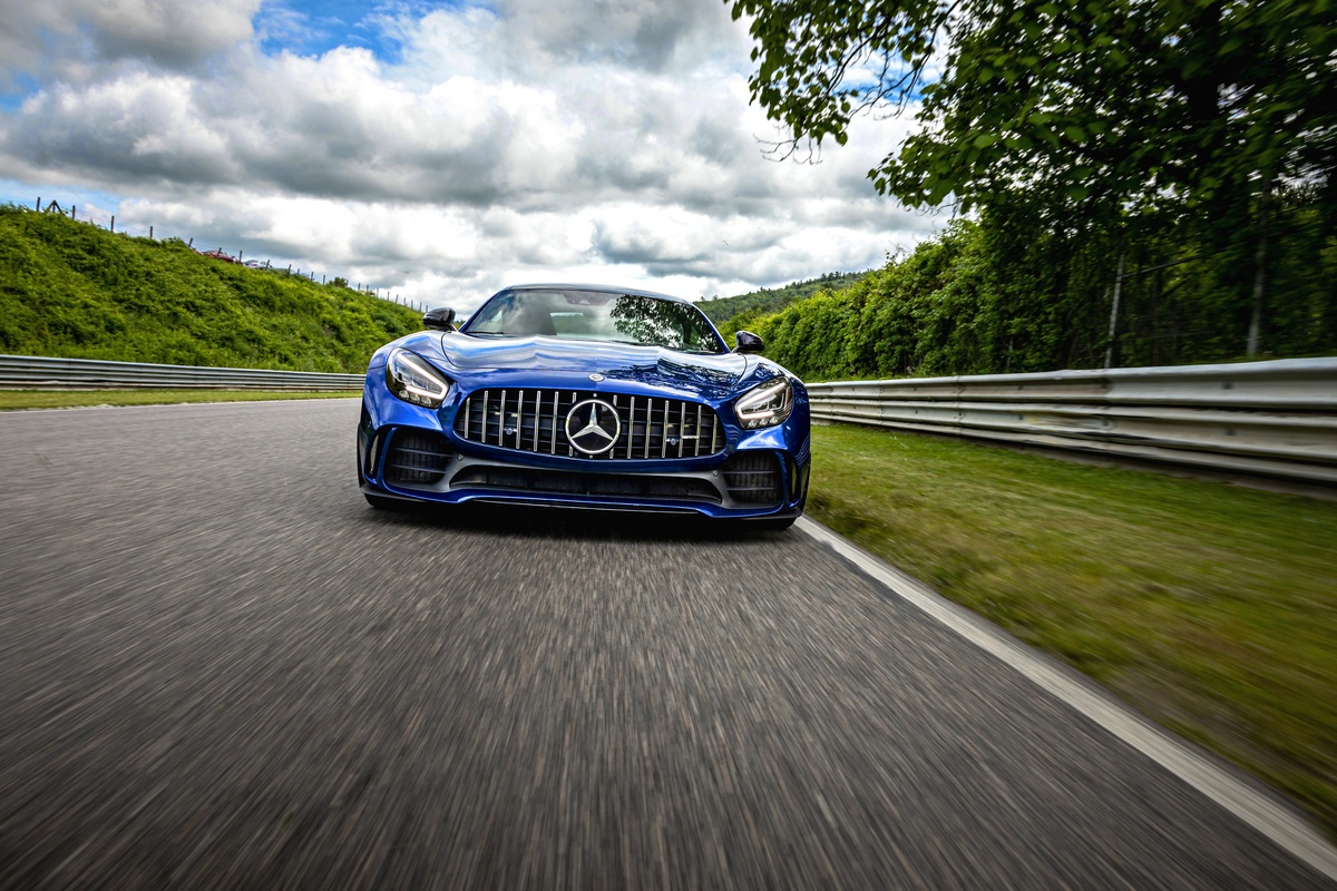 Blue Mercedes-AMG vehicle racing on Lime Rock Park track