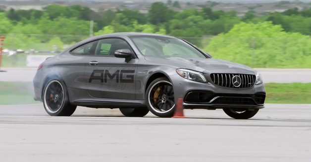 Gray Mercedes-AMG vehicle name drifting around orange cone